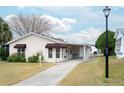 Charming single-story home includes a covered carport and a well-maintained front yard at 1207 Palmetto Dr, Lady Lake, FL 32159