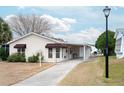 Tan single story home with a long driveway and carport at 1207 Palmetto Dr, Lady Lake, FL 32159