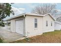 White single car garage with a window and attached covered carport at 1207 Palmetto Dr, Lady Lake, FL 32159