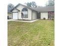 Front view of a single story house with a spacious yard at 12703 Whiterapids Dr, Orlando, FL 32828