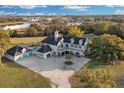 Aerial view showcasing a grand home, pool, expansive grounds, and scenic waterfront at 1730 Connecticut Ave, St Cloud, FL 34769