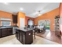 Open kitchen and dining area featuring modern island, tile floors, and seamless access to outdoor patio at 290 Clydesdale Cir, Sanford, FL 32773