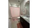 Bathroom with a granite countertop, decorative wall decals, and pink shower curtain at 3072 Cassidy Ln, Haines City, FL 33844