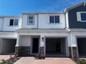 Charming townhome featuring a two-car garage, brick accents, and manicured landscaping at 5108 Rain Shadow Dr, St Cloud, FL 34772