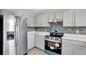 Modern kitchen with gray cabinets, new appliances, and tile backsplash at 1135 Madeira Key Way Way, Orlando, FL 32824