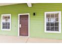 Exterior view of condo building entrance with green siding at 114 Watling Way # 114, Davenport, FL 33897