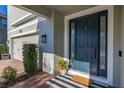 Modern front door with stylish striped doormat and landscaping at 15107 Lake Claire Overlook Dr, Winter Garden, FL 34787
