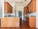 Kitchen with wood cabinets, granite countertops, and tile flooring at 1717 Minnow Ct, Poinciana, FL 34759