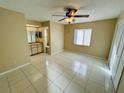 Spacious main bedroom featuring a ceiling fan, tile floors, and an ensuite bathroom at 3303 Jon Jon Dr, Orlando, FL 32822