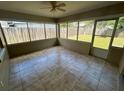 Tile-floored sun room with views of the fenced backyard and access to the outdoors at 3303 Jon Jon Dr, Orlando, FL 32822