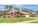 Brick house with a landscaped lawn and two-car garage at 340 Plantation Club Dr, Debary, FL 32713