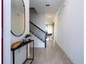 Bright entryway with tile flooring, a modern mirror, and staircase at 4447 Scene Ln, Kissimmee, FL 34746