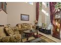 Cozy living room featuring high ceilings, large windows, and elegant furniture, offering a comfortable space at 4943 Cains Wren Trl, Sanford, FL 32771