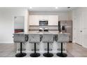 Bright kitchen with stainless steel appliances, white cabinets and a spacious island with bar stool seating at 523 Lazio Cir, Debary, FL 32713