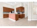 The kitchen features pendant lighting, wood cabinetry, stainless appliances, and tiled backsplash at 5400 Emerald Bay Ln, Lady Lake, FL 32159