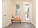 Bright entryway features stylish door with glass insert, neutral walls, and wood-look floors at 7958 Delwin Ln, Kissimmee, FL 34747