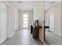 Bright entryway with tile flooring, console table, and 3D wall accent at 8828 Cruden Bay Ct, Davenport, FL 33896