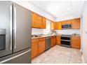 Kitchen with light wood cabinets, granite counters, and stainless steel appliances at 901 S Solandra Dr, Orlando, FL 32807