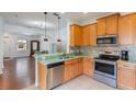 Kitchen with wood cabinets, stainless steel appliances, and green countertop at 13730 Lensdale Ln, Windermere, FL 34786