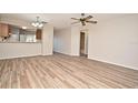 Open-concept living room with wood-look flooring that seamlessly flows into other rooms at 144 Reserve Cir # 112, Oviedo, FL 32765