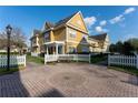 Inviting yellow townhomes with white picket fences and a communal brick courtyard with a bench at 2622 Lodi Cir # 103, Kissimmee, FL 34746