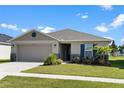 One-story home with a two-car garage, landscaping, and a neutral color palette at 3220 Sweet Acres Pl, St Cloud, FL 34772
