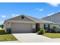 One-story home with a two-car garage, landscaping, and a neutral color palette at 3220 Sweet Acres Pl, St Cloud, FL 34772