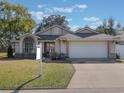 Charming single-story home with a well-manicured lawn and an attached two-car garage at 349 New Waterford Pl, Longwood, FL 32779