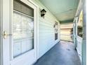 Inviting front porch features a white picket fence, glass door, and shade from the bright sunlight at 511 Coventry Ct, Mount Dora, FL 32757