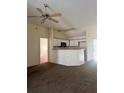 Open living room and kitchen area features a ceiling fan and neutral color palette at 511 Coventry Ct, Mount Dora, FL 32757