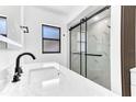 Modern bathroom with sleek, black-framed glass shower, large mirror, and marble countertops at 5300 Lido St, Orlando, FL 32807