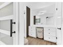 Bright bathroom featuring a marble countertop, white cabinets, modern lighting, and stylish laundry basket at 5300 Lido St, Orlando, FL 32807