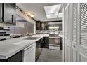 Galley kitchen with dark cabinets, white counters and appliances at 5419 Fairwood Way # 305, Orlando, FL 32808
