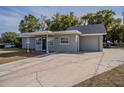 Newly renovated gray house with a driveway and mature trees at 5624 Balboa Dr, Orlando, FL 32808