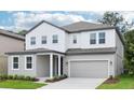 Stylish two-story home showcasing a gray and white exterior with a two-car garage at 5680 Brosnan Rd, St Cloud, FL 34771