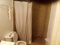 Bathroom with shower, toilet, and tiled walls at 7628 Forest City Rd # 056 Aka H, Orlando, FL 32810