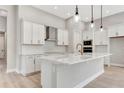 Island kitchen with white cabinets and quartz countertops at 1062 Liliana Dr, Deland, FL 32724