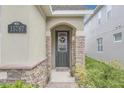 Gray front door with glass inserts and stone surround at 15787 Avenue Of The Arbors, Winter Garden, FL 34787