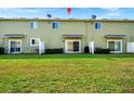 View of the back of the townhome with a large grassy area at 1927 Chatham Place Dr, Orlando, FL 32824