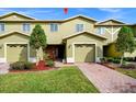 Front view of a light green two-story townhome with a brick walkway at 1927 Chatham Place Dr, Orlando, FL 32824