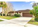 House exterior showcasing a brown garage door, landscaping, and driveway at 2712 Ceram Ave, Orlando, FL 32837