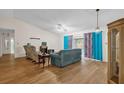 Living room with teal sofa, armchairs, and wood-look flooring at 2712 Ceram Ave, Orlando, FL 32837