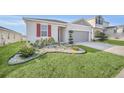Curb appeal of a one-story home with red shutters and a two-car garage at 283 Archer Way, Haines City, FL 33844