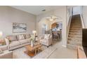 Open living room with beige sofas, a view of the kitchen and staircase at 4052 Falling Lilly Ct, Winter Springs, FL 32708