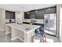 Stylish kitchen with dark wood cabinets, stainless steel appliances, and bright countertops at 445 Kestrel Dr, Groveland, FL 34736