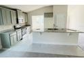 Modern kitchen with gray cabinets, granite countertops, and stainless steel appliances at 4450 Sagefield Dr, Harmony, FL 34773