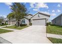 A well-maintained single Gathering home boasts a concrete driveway and a two car garage, with manicured landscaping at 782 Grand Hilltop Dr, Apopka, FL 32703