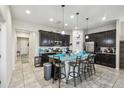 The spacious kitchen is equipped with an island, granite countertops, dark cabinets, and stainless steel appliances at 782 Grand Hilltop Dr, Apopka, FL 32703