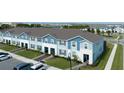 New townhomes with blue and white exteriors, landscaped lawns, and spacious parking areas at 107 Jetty Way, Davenport, FL 33897