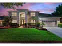Two-story house with a three-car garage, landscaping, and a paved driveway at 13005 Islamorada Dr, Orlando, FL 32837